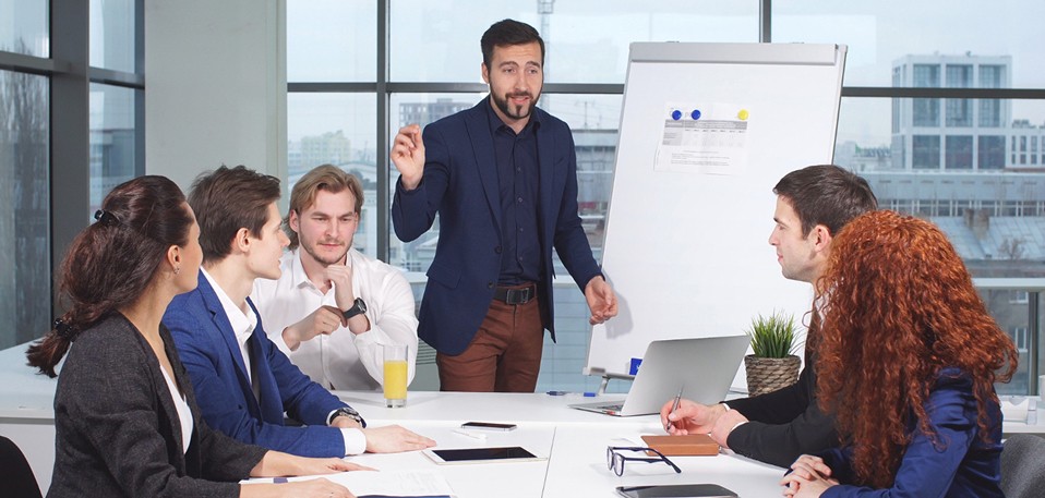 Manager coaching a young employee on professional phone and communication skills in the workplace