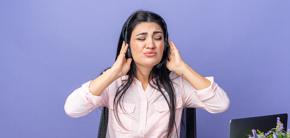 Young professional feeling anxious about answering a work phone call in an office environment