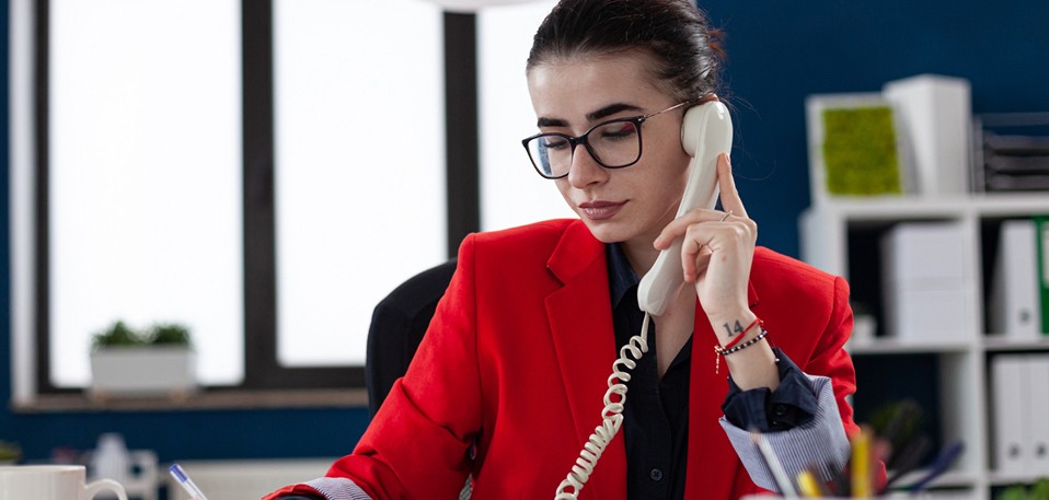 Employee answering a business phone professionally with excellent customer service skills